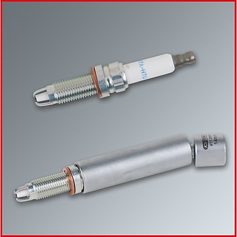 Zwei Zündkerzen, eine mit Keramik, eine mit Metall, auf grauem Hintergrund.